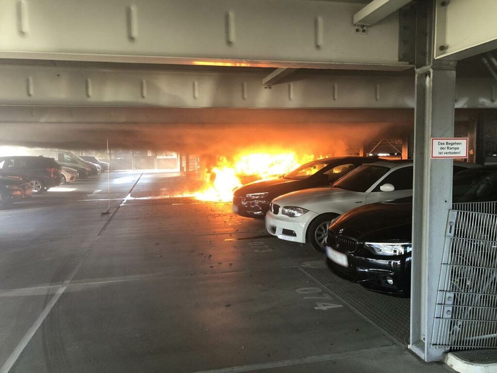 Autos in Parkhaus in Flammen